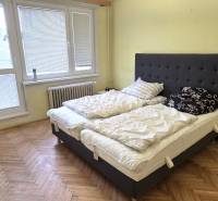 A bedroom with a large bed and a wooden decor floor in a 3-room apartment.
