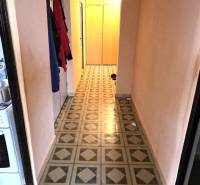 A narrow corridor in a 3-room apartment with colorful patterned linoleum.