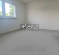 A bright room with a window in a family house, white wall and smooth floor.