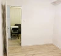 A room with a wooden decor floor in a 3-room apartment, entrance to another room.