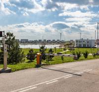 A system of wind turbines and a lake on Am Seepark street in Kittsee behind the barrier.