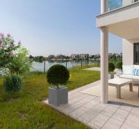 Terrace with a 4-room apartment in Kittsee, Am Seepark with a view of the lake and a garden.