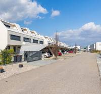 Row houses in Kittsee on Am Seepark Street with parking and a spacious road.
