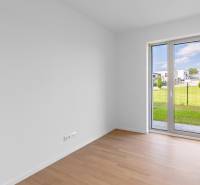 A room with a wooden decor floor in a 4-room apartment with a garden view.