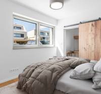 Bedroom with built-in wardrobe, wood-patterned flooring, and large window, 4-room apartment.