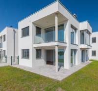 Modern facade of a 4-room apartment in Kittsee on Am Seepark street with an adjacent garden.