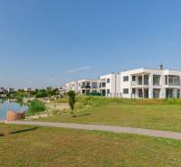 Modern buildings by the lake in Kittsee, at Am Seepark, in a sunny landscape.