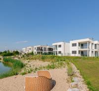 A lakeside 4-room apartment in Kittsee, Am Seepark, with modern buildings by the lake.