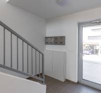 Entrance hallway in a 4-room apartment with glass doors and a staircase.