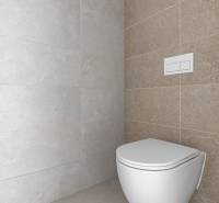 A toilet in the bathroom with light tiles in a 4-room apartment.