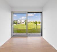 A room in a 4-room apartment with a wooden decor floor and a view of the garden.