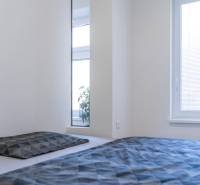 Bright bedroom with a bed and a window with blinds in a 2-room apartment.