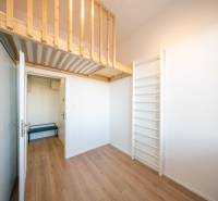 A room in a 2-room apartment with a climbing frame, a raised loft, and a floor with a wooden decor.