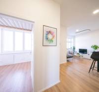 Interior of a 2-room apartment with a wooden decor floor and a colorful painting on the wall.