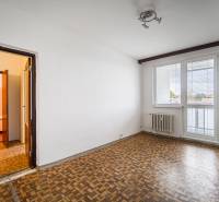 A room in a 3-room apartment with a wooden decor floor and a view through the window.