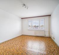 A room with white walls and a wooden decor floor in a 3-room apartment.
