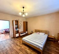Bedroom in a family house with a bed and a wooden decor floor.