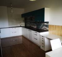 A kitchen in a 3-room apartment with a glossy floor and modern cabinets.
