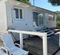 A white wooden house with loungers on a pebble terrace in the town of Vodice, Croatia.