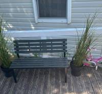 Bench, flower pots, bicycle on the floor with wooden decor at Unusual Properties.