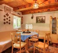 Traditional cottage with a wooden ceiling, rustic furniture, and a cozy seating area around the table.
