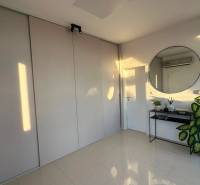 Interior of a 3-room apartment with a large round mirror, a plant, and a built-in wardrobe.