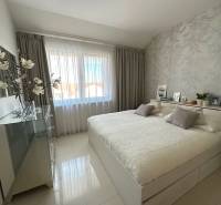 A bright bedroom in a 3-room apartment with decorative pillows and a large mirror.