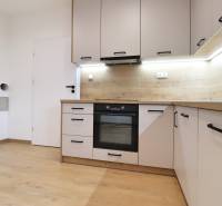 A kitchen in a family house with a wooden decor floor and built-in appliance.