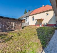 The garden of a family house in Lednické Rovne on Sklárska street shows a wooden extension and a walkway.