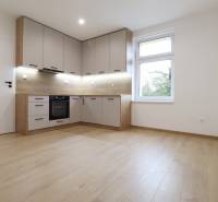 A kitchen in a family house with a wooden decor floor, built-in appliances, white walls.