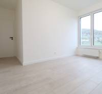 A bright room with white walls and a floor with a wood decor in a 4-room apartment.