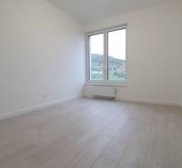 A room in a 4-room apartment with a wooden decor floor and a large window.