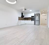 Kitchen in a 4-room apartment, bright space, white kitchen cabinets, floor with wood decor.