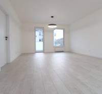 A spacious room with a light wood-patterned floor in a 4-room apartment.