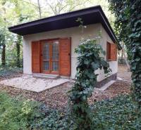 A cottage in Radvani nad Dunajom surrounded by greenery, wooden shutters, terrace.