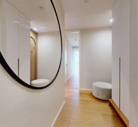 A hallway with a mirror, a wooden decor floor, and a built-in wardrobe in a 4-room apartment.