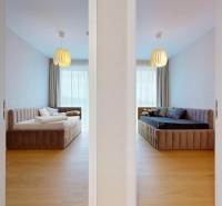 Two bedrooms in a 4-room apartment with wood-patterned flooring and modern lighting.