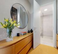 4-room apartment with flowers on wooden furniture, floor with wooden decor, mirror on the wall.