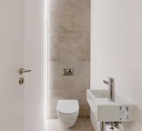 Bathroom with toilet and sink in a 4-room apartment, bright walls and floor.