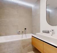 A bathroom in a 4-room apartment with a bathtub, a sink, and an oval mirror.