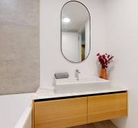 A bathroom with a mirror and a wooden cabinet in a 4-room apartment.