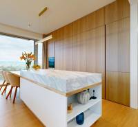 A kitchen in a 4-room apartment with a marble island and a wooden decor floor.