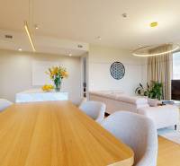 Living room in a 4-room apartment with a large window, wooden decor flooring, and stylish furniture.