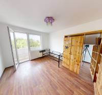 A spacious room with a wooden decor floor and access to a balcony in a 4-room apartment.