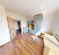 A room in a 4-room apartment, wooden decor flooring, built-in furniture, large window.