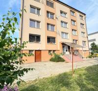 A four-story building surrounded by greenery in Horné Obdokovce, ideal for a 4-room apartment.
