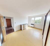 A room with light furniture and a large window in a 4-room apartment.