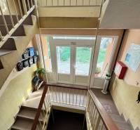 Staircase in a 4-room apartment with a bright hallway, railing, and a view of the exterior.