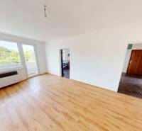 A spacious living room with light-colored walls and a wooden decor floor in a 4-room apartment.