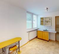 A kitchen in a family house with a sink, a bar counter, and a window.